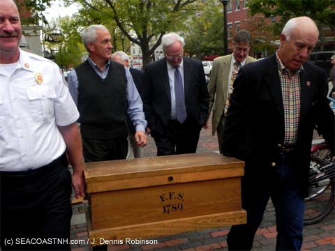 Fire chief and historian Steve Achilles (left) and Federal Fire Society president Peter Rice (right) carry the  1789 FFS archives throuh Market Square in Portsmouth, NH. Histoiran Peter Lamb, Tom Watson, and Dick Kaiser follow close behind. / (c) J. Dennis Robinson photo 